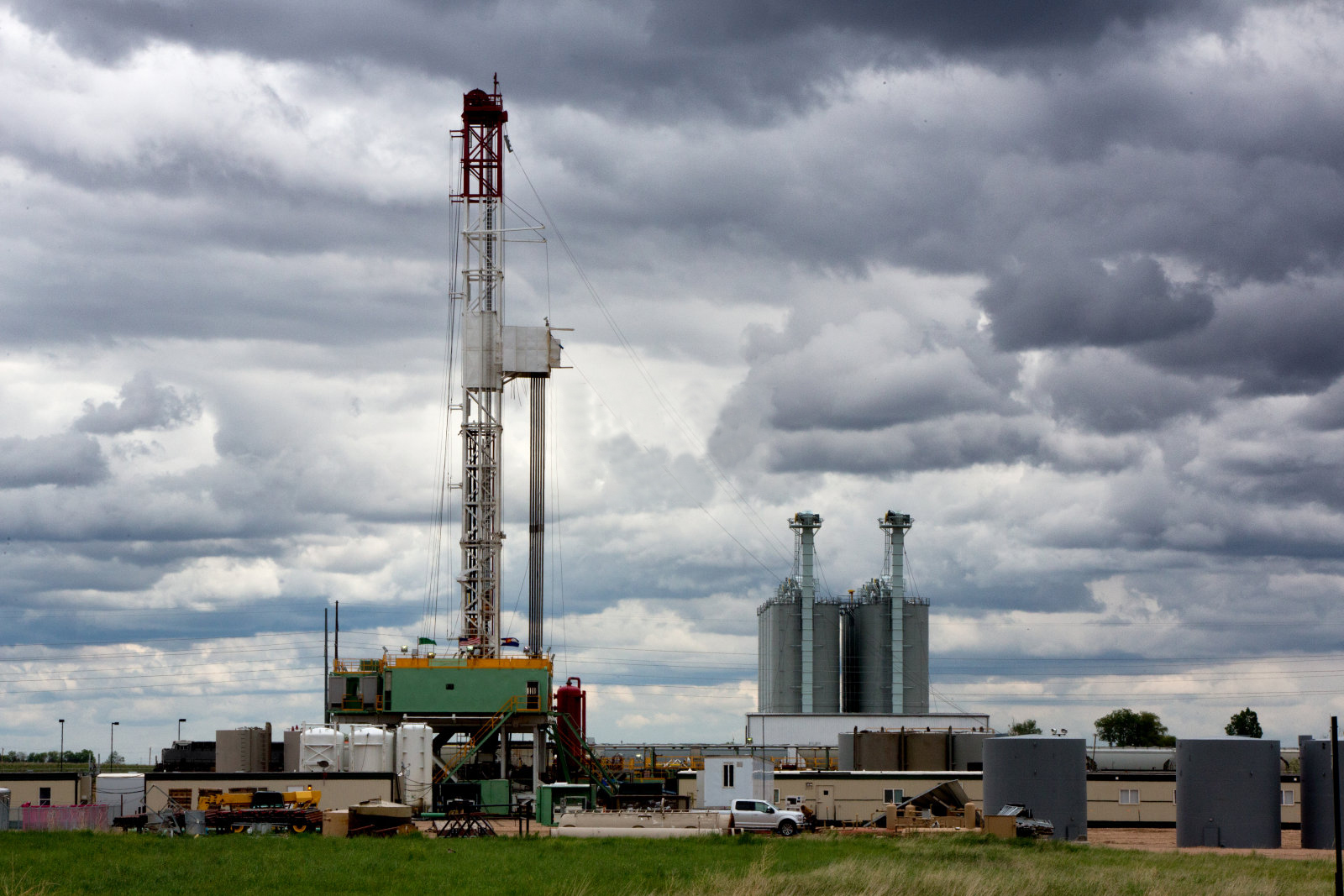 Rig pengeboran minyak fracking gedhe ing sangisore langit mendhung sing apik